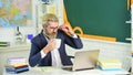 Online course. Senior professor use computer. Computer teacher drink tea at school desk. Bearded man work in computer