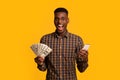 Online credit. Funny young black man holding smartphone and dollar cash Royalty Free Stock Photo