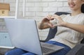 Online dating. Cropped view of young woman showing heart with hands to her boyfriend while talking online on laptop Royalty Free Stock Photo