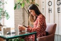 Online dating, Love at distance. Woman in cafe using dating app and swiping user photos. Young woman using mobile phone Royalty Free Stock Photo