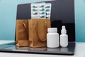 Online delivery and shopping concept. Paper bags with prescription drugs and pills and conteiners on laptop on blue Royalty Free Stock Photo