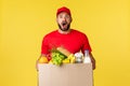 Online delivery, shopping and food order concept. Excited and amused courier in red uniform, bearde delivery man gasping Royalty Free Stock Photo