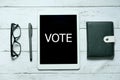 Online digital vote politics election government democracy technology concept. Top view of glasses,pen,notebook and tablet written