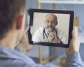Online doctor and patient. A patient with a tablet makes a video call a conference call with a practicing doctor online