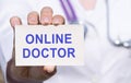 Online doctor text on medical card in doctors hands