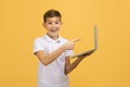Online Education Concept. Happy teen boy pointing at laptop in his hand Royalty Free Stock Photo