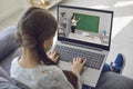 Online education. Little girl watching young teacher give lesson on webcam. Child studying on laptop from home Royalty Free Stock Photo