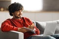 Online Education. Handsome young indian man using laptop and taking notes Royalty Free Stock Photo