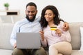 Black couple using laptop and debit credit card at home Royalty Free Stock Photo