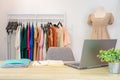 Online female clothes shop with laptop, notebook, document file on desk and casual cloth on clothes line and mannequin Royalty Free Stock Photo