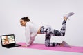 Online fitness at home. Caucasian girl does exercises watching the video course the trainer has a laptop at home. Sport Royalty Free Stock Photo