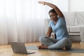 Online Fitness. Smiling Black Lady Training In Front of Laptop At Home