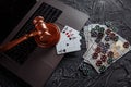 Online gambling and justice theme, cards, playing chips and judge gavel on laptop keyboard Royalty Free Stock Photo