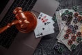 Online gambling and justice theme, cards, playing chips and judge wooden gavel on laptop keyboard Royalty Free Stock Photo