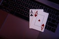 Online gambling theme. Aces on a laptop's keyboard. Top view Royalty Free Stock Photo