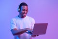 Online Gaming. Portraif Of Happy Black Man In Wireless Headphones Using Laptop