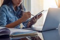 Online learning, home school concept.Young asian woman using digital tablet, work on laptop computer Royalty Free Stock Photo