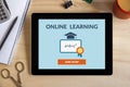 Online learning concept on tablet screen with office objects Royalty Free Stock Photo