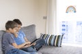 Online learning at home, distance learning during Coronavirus quarantine. Boy with tablet computer sitting in the room