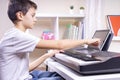 Boy learning music online. Child watching video tutorial at tablet computer and playing digital piano at home Royalty Free Stock Photo
