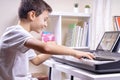 Boy watching video lesson at tablet computer and having fun playing piano at home. Online learning remote education Royalty Free Stock Photo