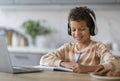 Online Lesson. Black Boy In Wireless Headphones Study With Laptop At Home Royalty Free Stock Photo