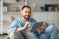 Online life concept. Happy young man using tablet computer, working or studying from home Royalty Free Stock Photo