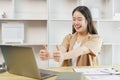 Online lifestyle concept A female staff making a facetime meeting with her co-workers and giving them a compliment by raising her