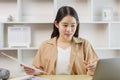 Online lifestyle concept A working woman checking for some information on the notebook which relates to the one on the paper Royalty Free Stock Photo