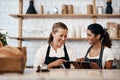 Online management makes a baristas life so much easier. two women using a digital tablet together while working in a Royalty Free Stock Photo