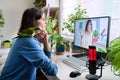 Online meeting of teenagers friends, guy with pet parrot at home talking to a female Royalty Free Stock Photo