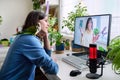 Online meeting of teenagers friends, guy with pet parrot at home talking to a female Royalty Free Stock Photo