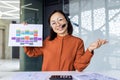 Online meeting video meeting discussion, Asian woman looking at camera and showing forex chart, businesswoman smiling Royalty Free Stock Photo