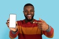 Online Offer. Excited Black Man Pointing At Big Blank Smartphone In Hand Royalty Free Stock Photo