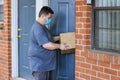 Online order home delivery, man medical mask with a box parcel in his hands of the coronavirus pandemic Royalty Free Stock Photo