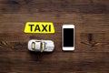 Online order a taxi set with car toy and mobile on wooden background top view mock up Royalty Free Stock Photo