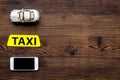 Online order a taxi set with car toy and mobile on wooden background top view mock up Royalty Free Stock Photo