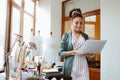 Online orders by email. Young woman tailor with laptop is answering emails Royalty Free Stock Photo