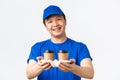 Online orders, takeaway and employees concept. Close-up of cute smiling male courier in blue uniform cap and t-shirt