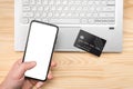 Online paying shopping, electronic payment with credit card, cell phone mockup, laptop over wooden table background, close up Royalty Free Stock Photo