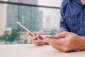 Online payment, Closeup young man hands holding a credit card and using smart phone for online shopping or reporting lost card Royalty Free Stock Photo