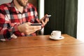 Online payment, focus man's hands holding credit card and using smartphone in coffee cafe for online shopping Royalty Free Stock Photo