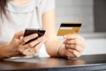 Online payment, women`s hands holding a credit card and using smart phone for online shopping Royalty Free Stock Photo