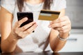 Online payment, women`s hands holding a credit card and using smart phone for online shopping Royalty Free Stock Photo