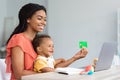 Online Payments. Black Woman With Little Baby using Laptop And Credit Card Royalty Free Stock Photo