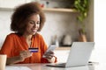 Online Payments. Black woman using smartphone and credit card at home office Royalty Free Stock Photo