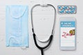 Online pharmacy. Application in smartphone for online ordering of medicines. Medical disposable face mask and the phone on a white