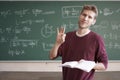 Online physics course young male teacher thumb up classroom with chalkboard with formulas copy space