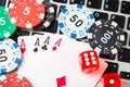 Online poker casino theme. Gambling chips with dice and aces playing cards on laptop Royalty Free Stock Photo