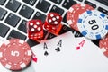 Online poker casino theme. Gambling chips with dice and playing cards on laptop Royalty Free Stock Photo